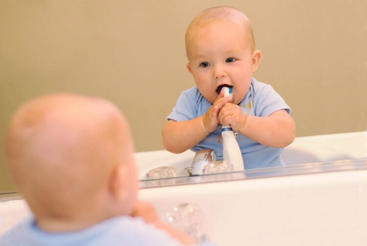 When should a child start brushing their teeth?